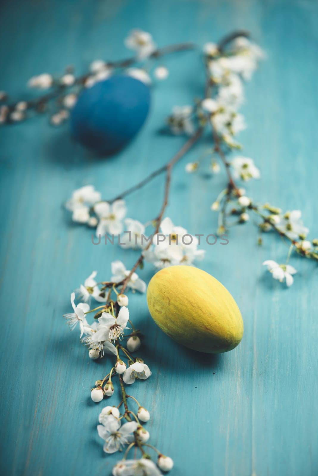 Colorful easter eggs on blue wooden table. Retro filter.