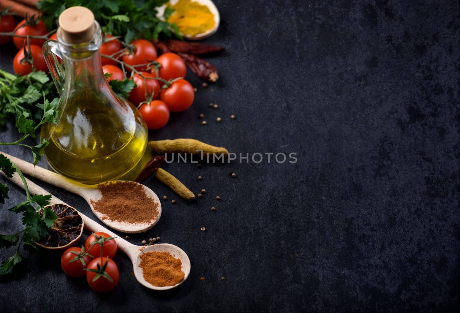 Various food ingredients and spices on rustic black background with copyspace.