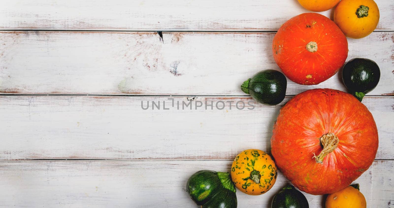 Colorful autumn pumpkins on white wooden table. Halloween and thanksgiving background cocnept.