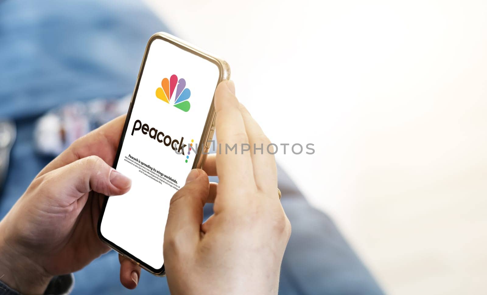 New York, USA, September 2021: woman launching the Peacock Tv mobile app on her smart phone. Peacock is an American video streaming service