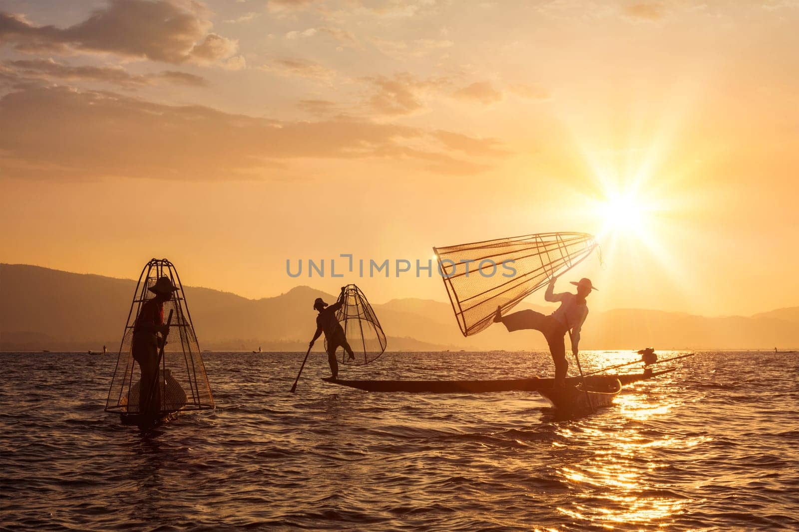 Myanmar travel attraction landmark - three traditional Burmese fishermen at Inle lake, Myanmar famous for their distinctive one legged rowing style