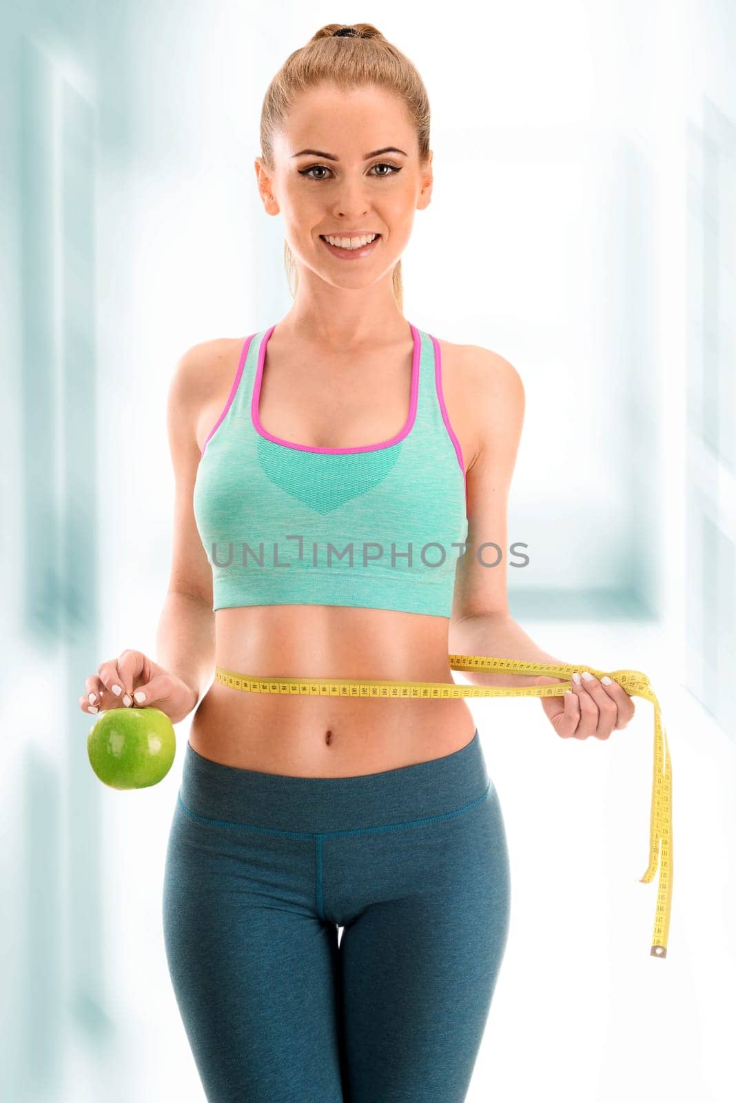 Young woman measuring herself. Weight loss.