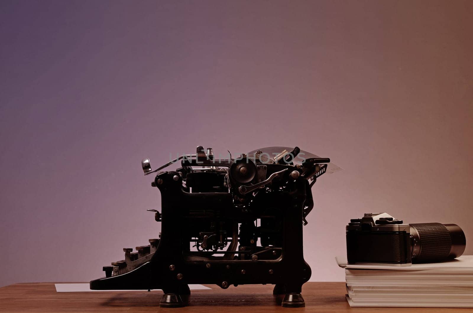 Old used typewriter with an old camera on an office table