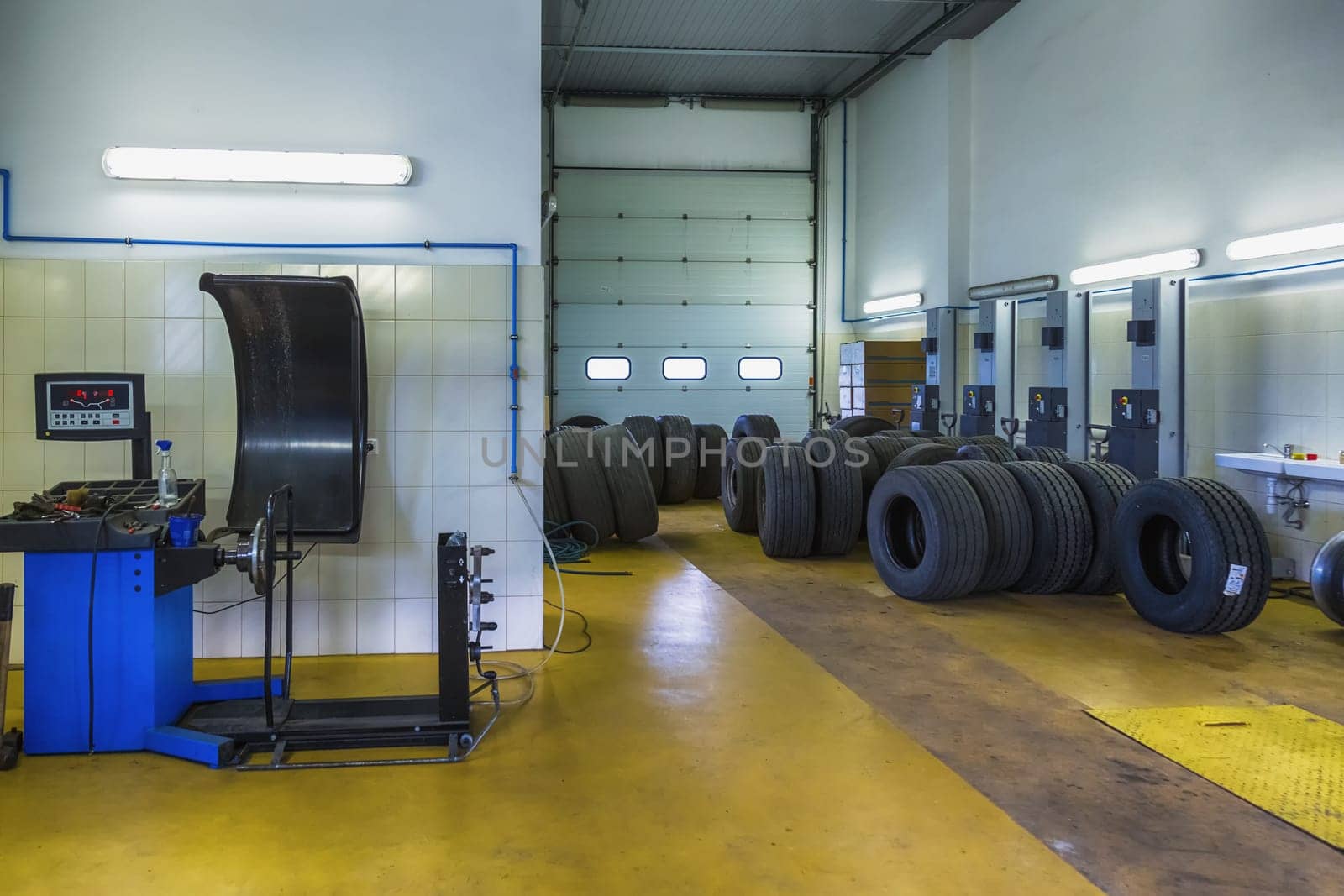 Truck tires or tyres repair shop service interior with wheel balancer