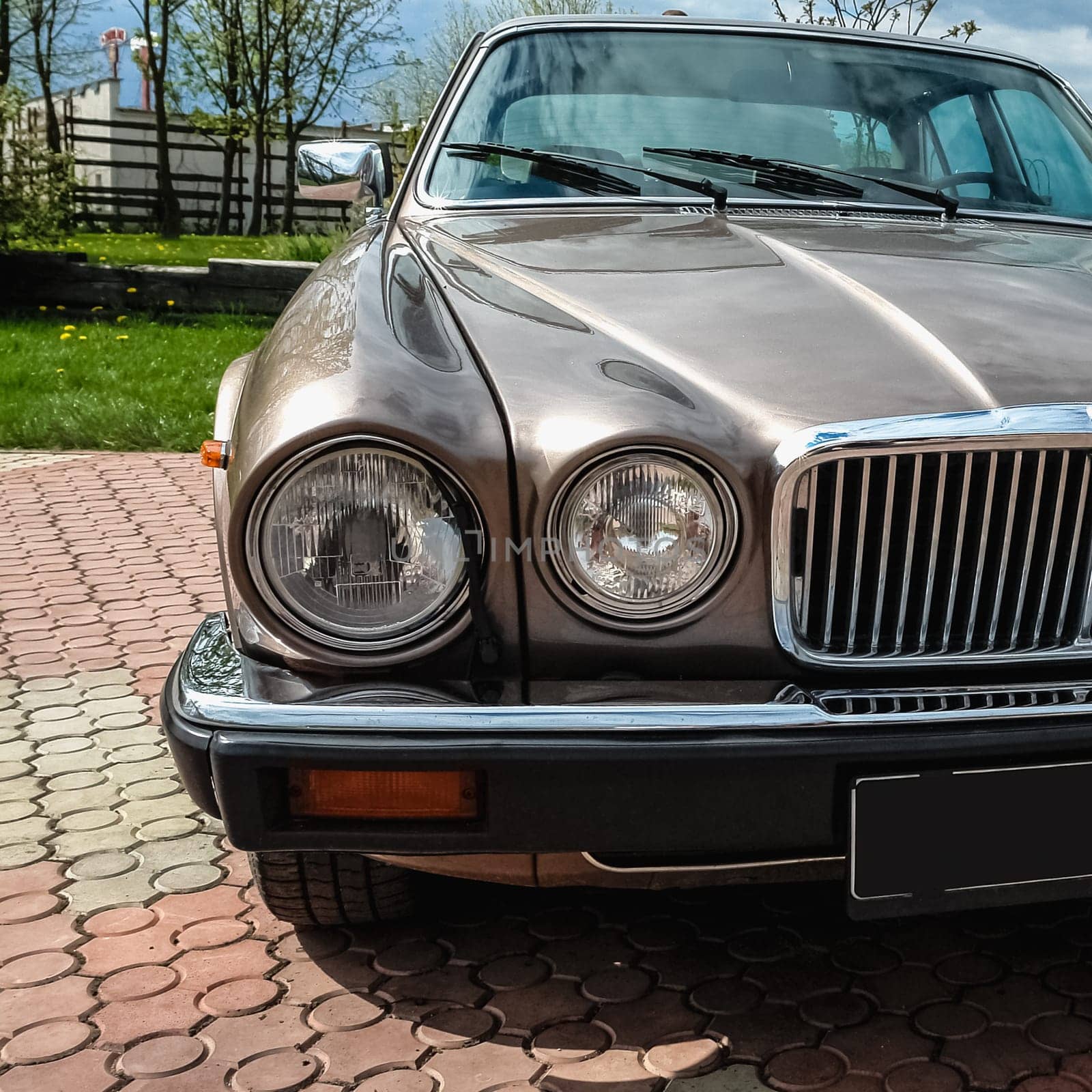 Old retro or vintage car or automobile front side with front lights or headlights and radiator grill