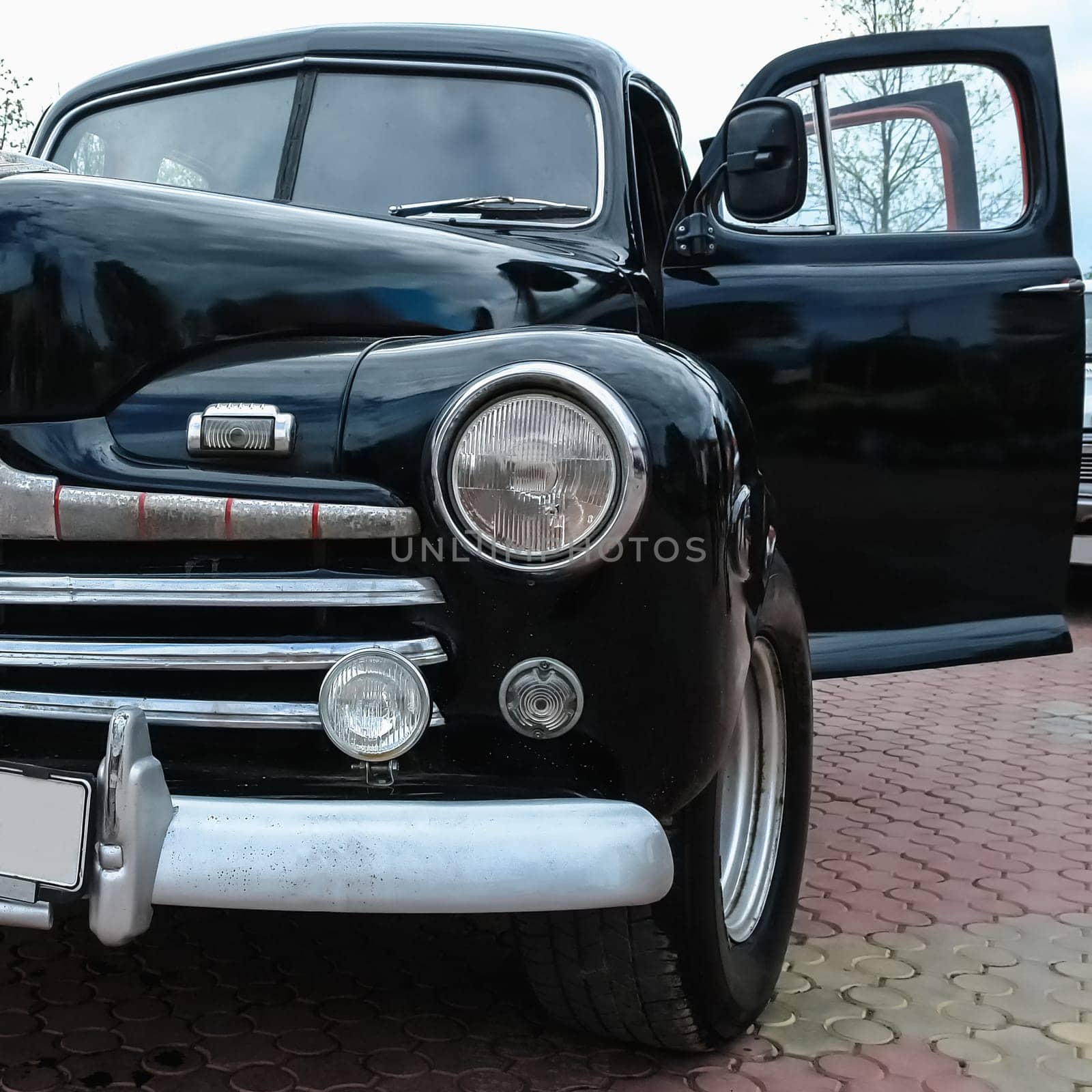 Old retro or vintage car or automobile front side with front lights or headlights and radiator grill