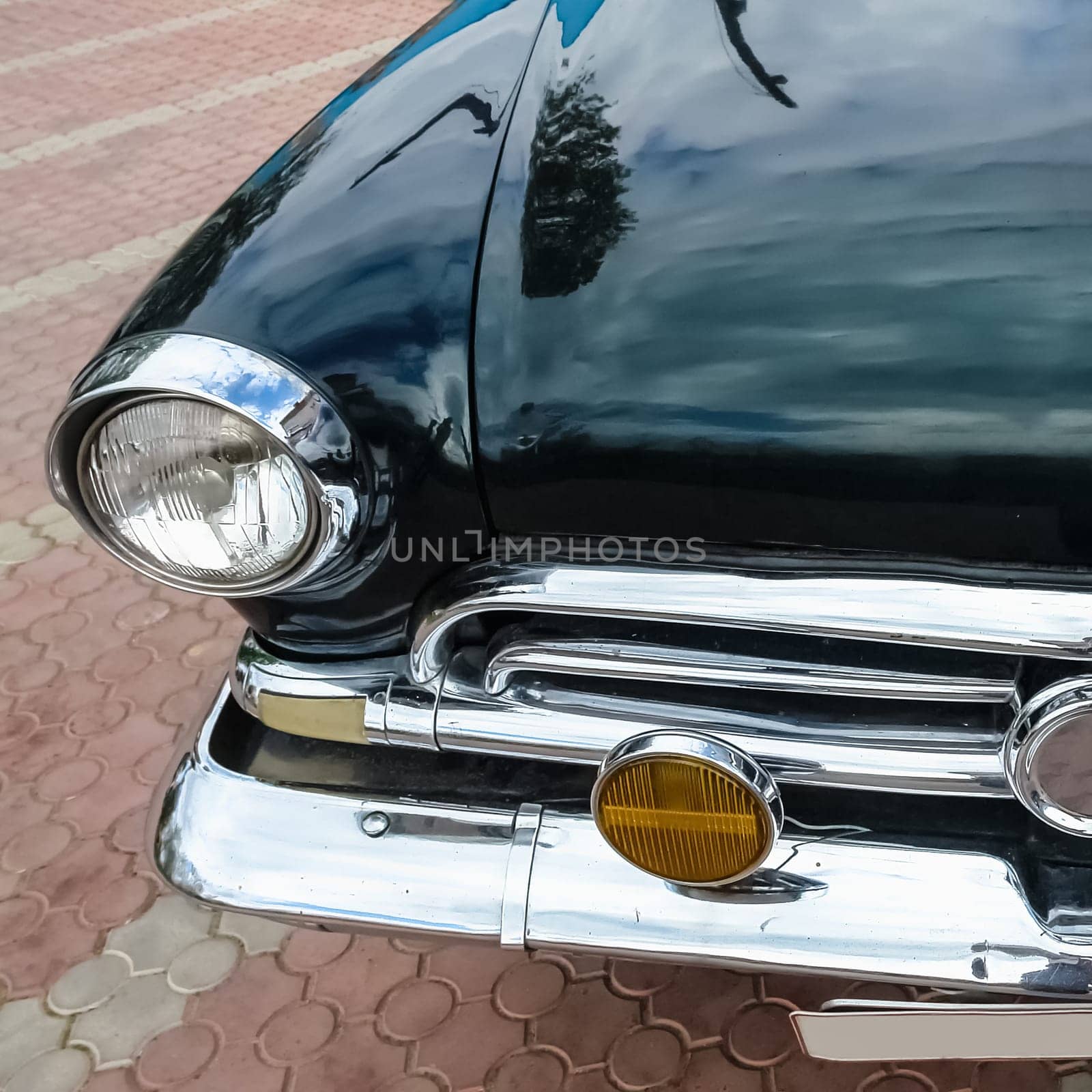 Old retro or vintage car or automobile front side with front lights or headlights and radiator grill