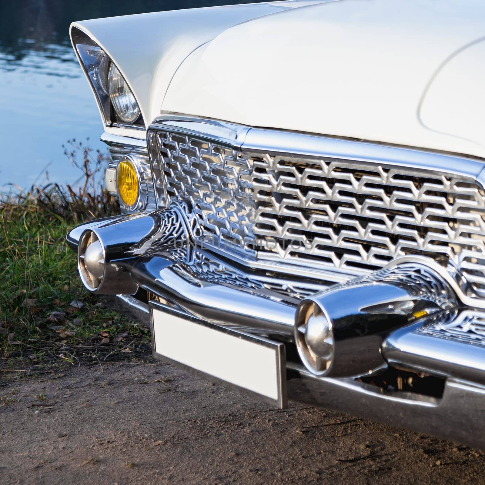 Old retro or vintage car or automobile front side with front lights or headlights and radiator grill