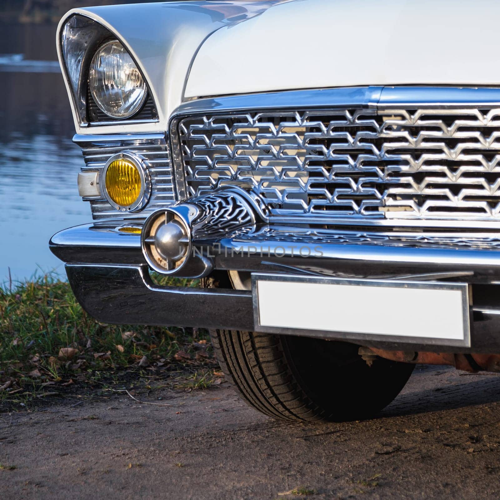 Old retro or vintage car or automobile front side with front lights or headlights and radiator grill
