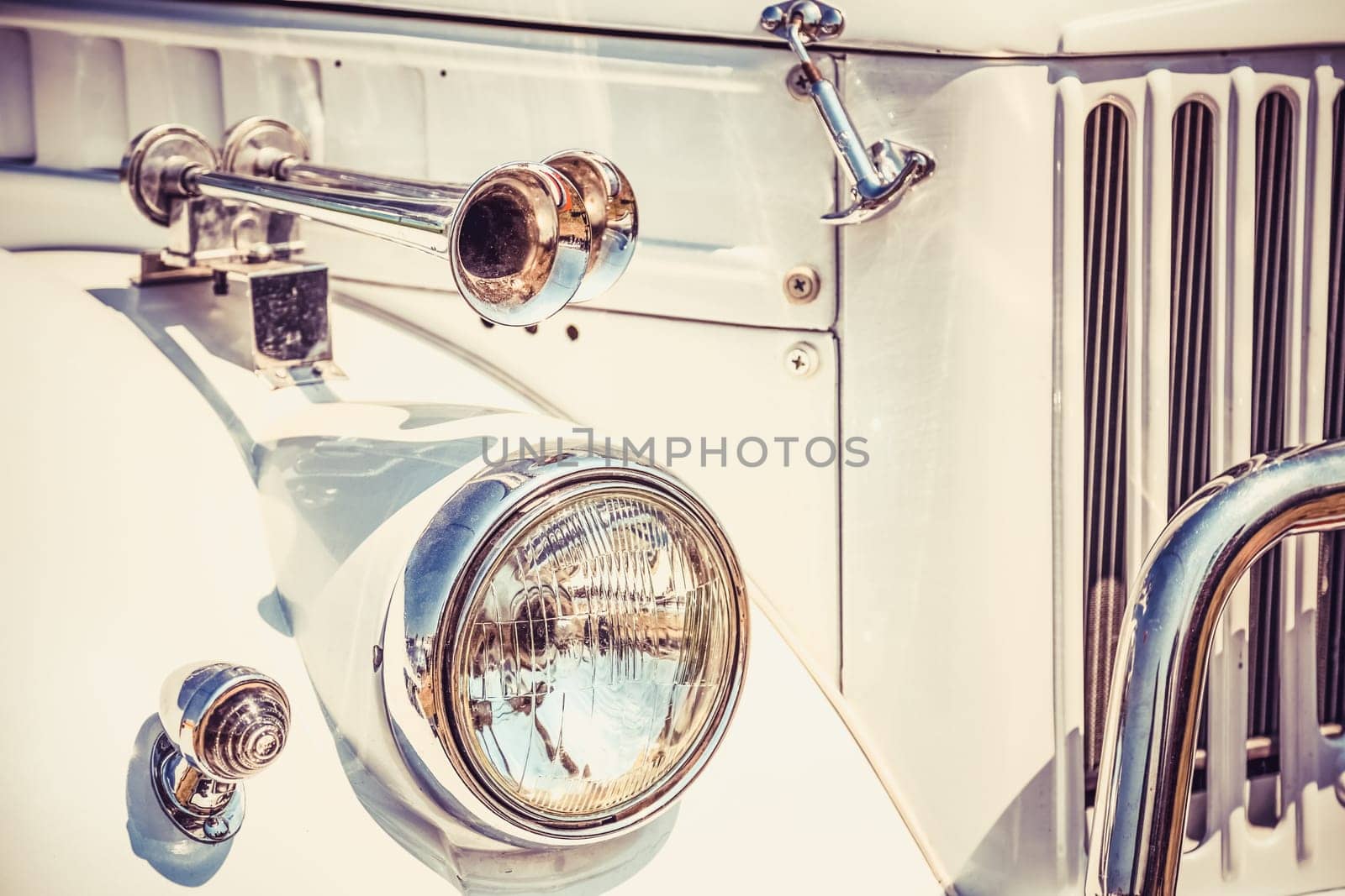 Old retro or vintage car or automobile front side with front lights or headlights and radiator grill. Processed by vintage or retro effect filter