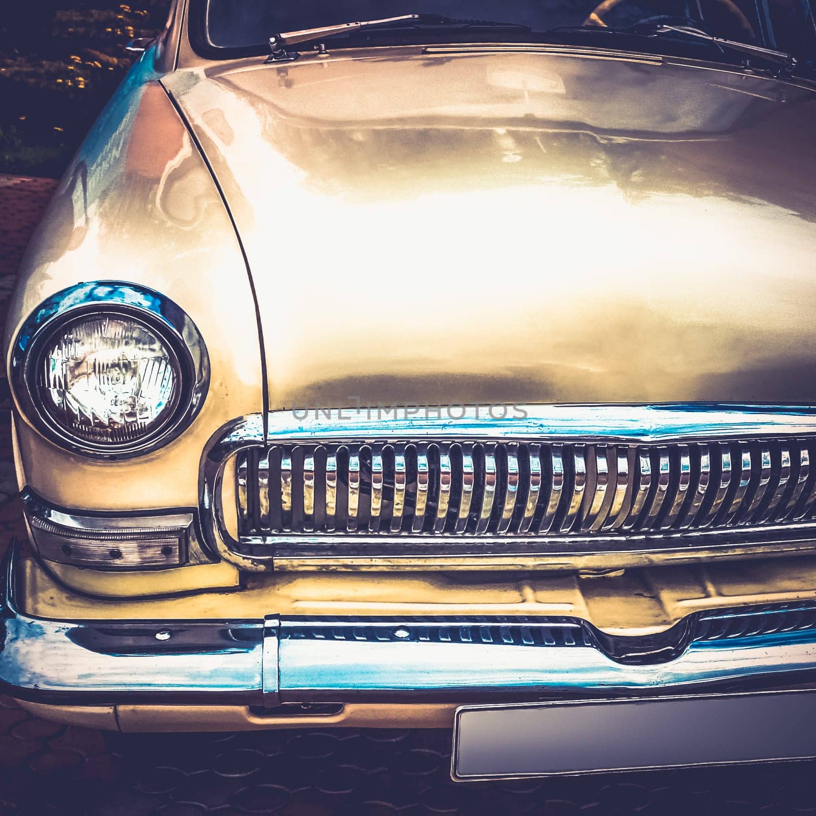 Old retro or vintage car or automobile front side with front lights or headlights and radiator grill. Processed by vintage or retro effect filter