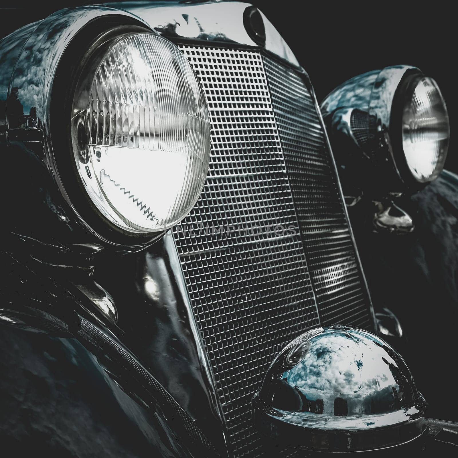 Old retro or vintage car or automobile front side with front lights or headlights and radiator grill. Processed by vintage or retro effect filter