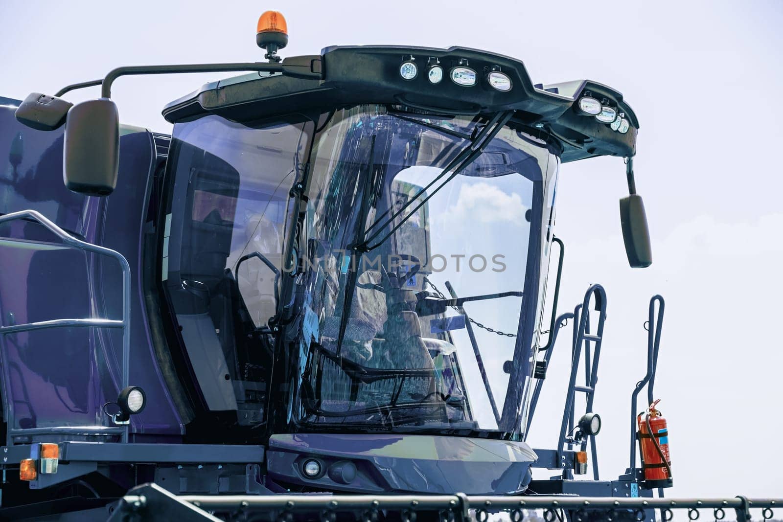Cab of combine harvester closeup on sky background