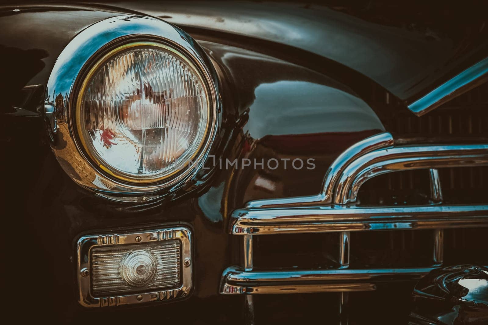 Front lights and radiator grill of an old vintage automobile. Processed by vintage or retro effect filter