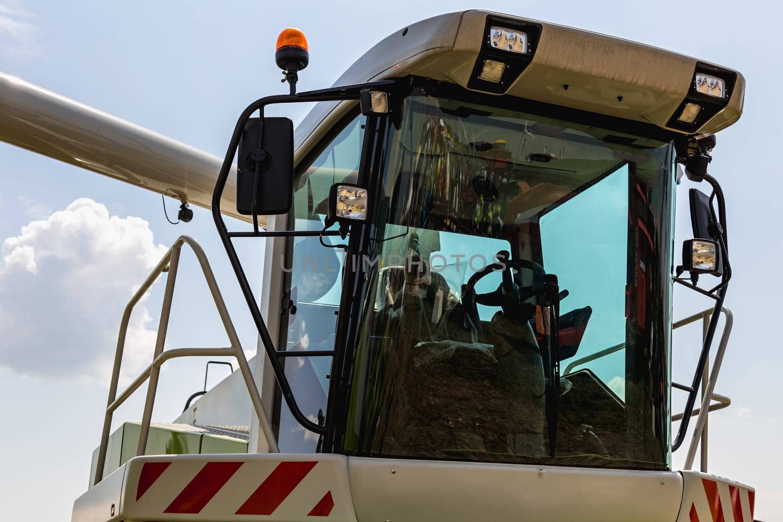 Cab of combine harvester closeup on sky background