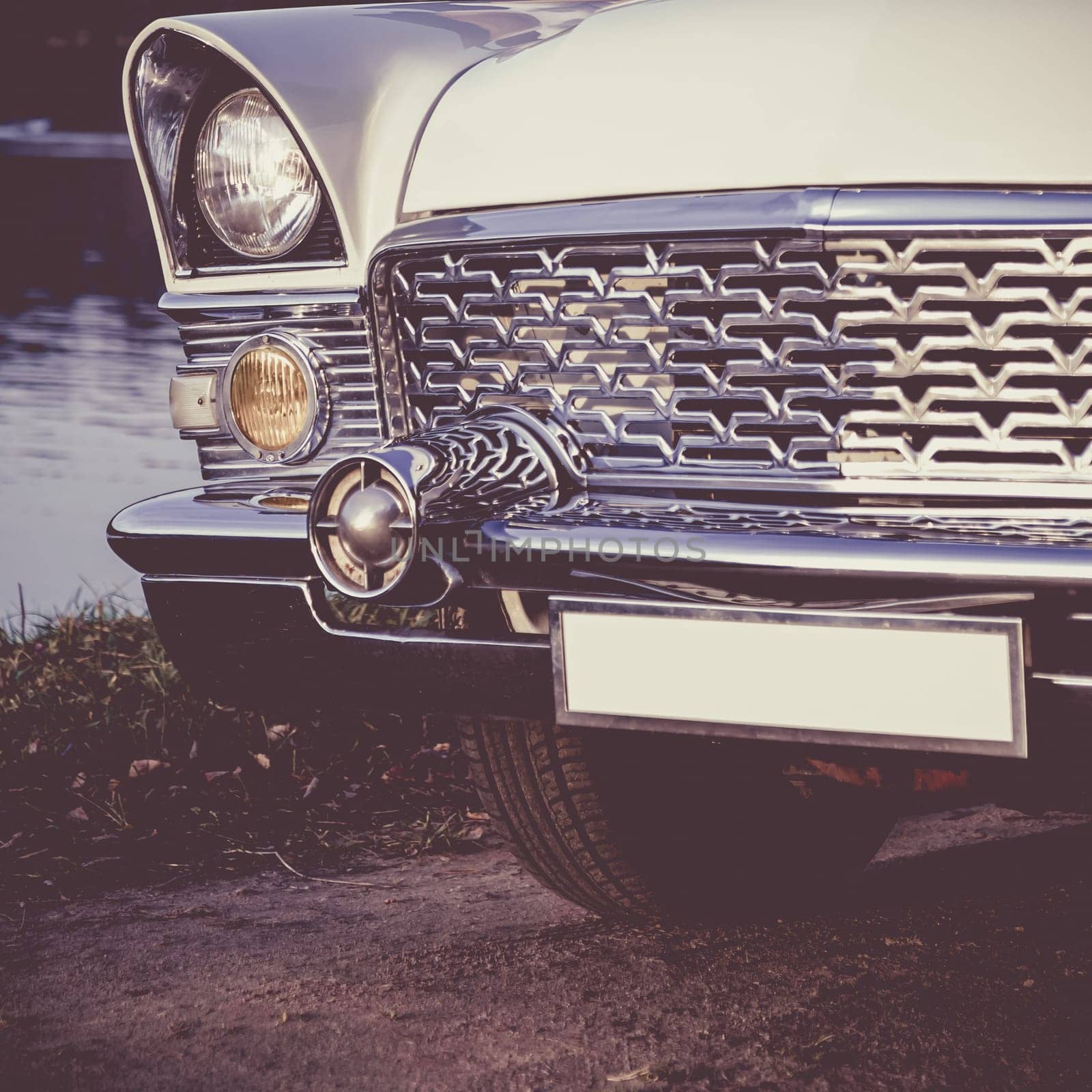 Old retro or vintage car or automobile front side with front lights or headlights and radiator grill. Processed by vintage or retro effect filter