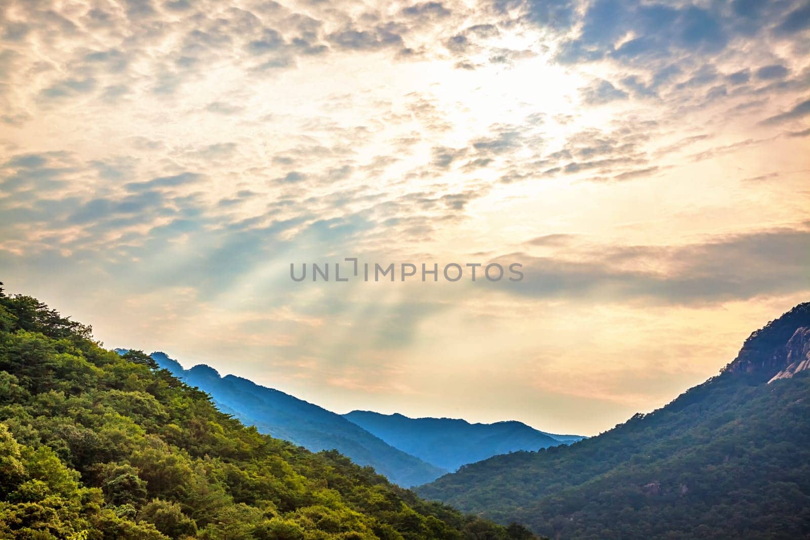 Mountains with green trees landscape and cloudy sky with sunbeams in South Korea