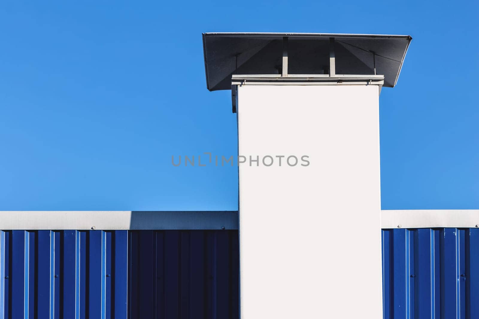 White chimney on building rooftop on blue sky background