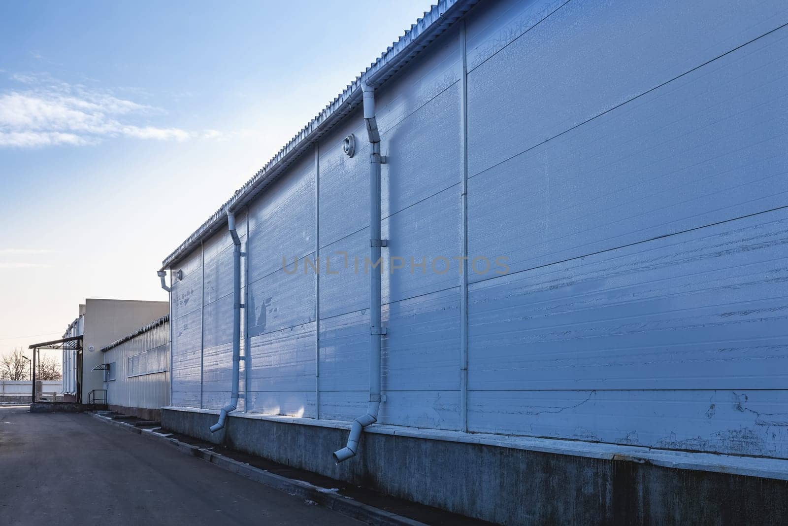 Plastic siding wall of industrial building with pipes