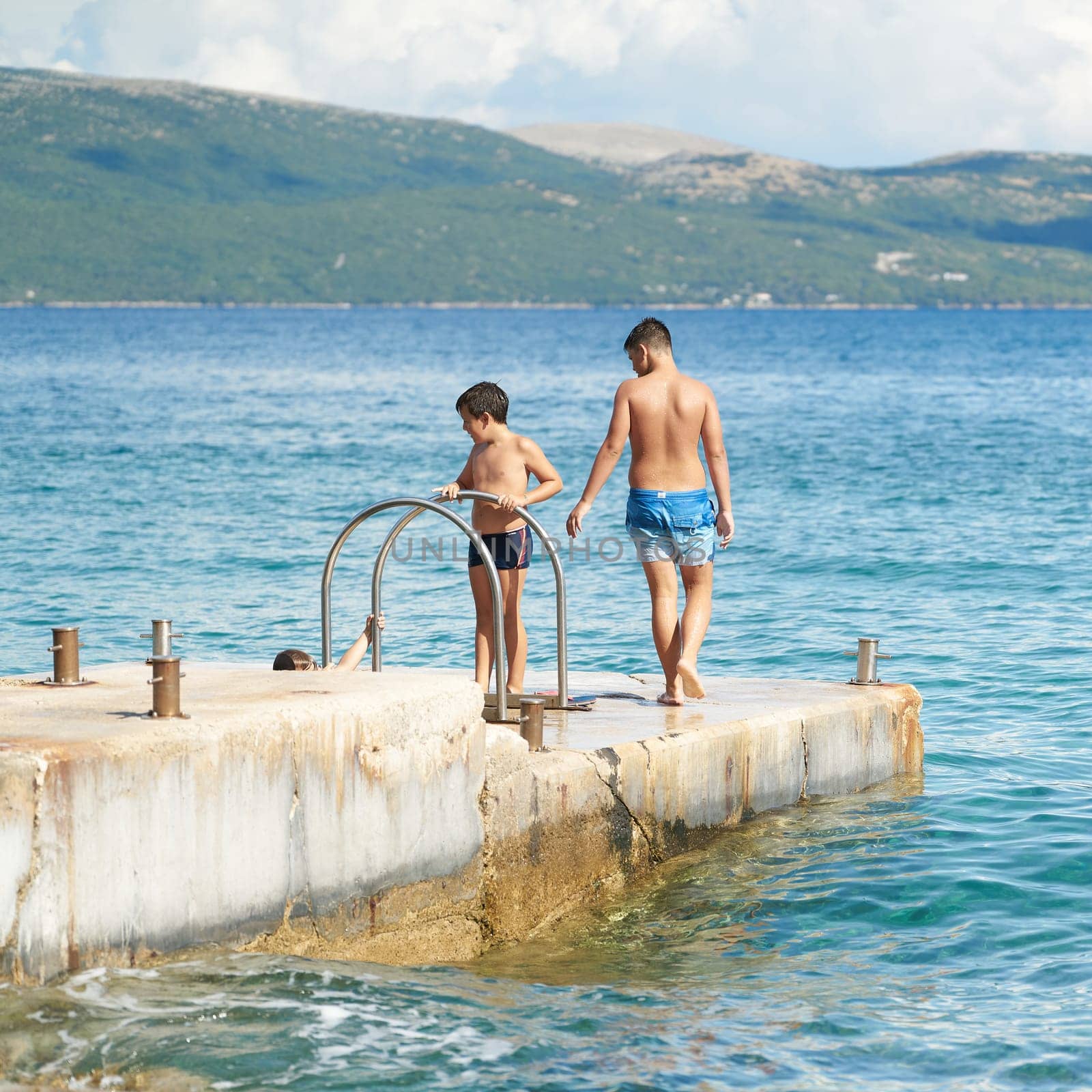 Children playing at a bathing place on the Adriatic Sea near the town of Krk in Croatia