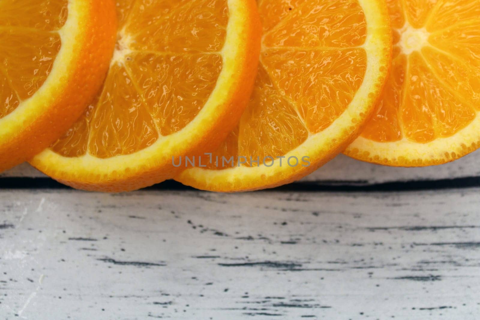 Large slices of orange on a wooden table..