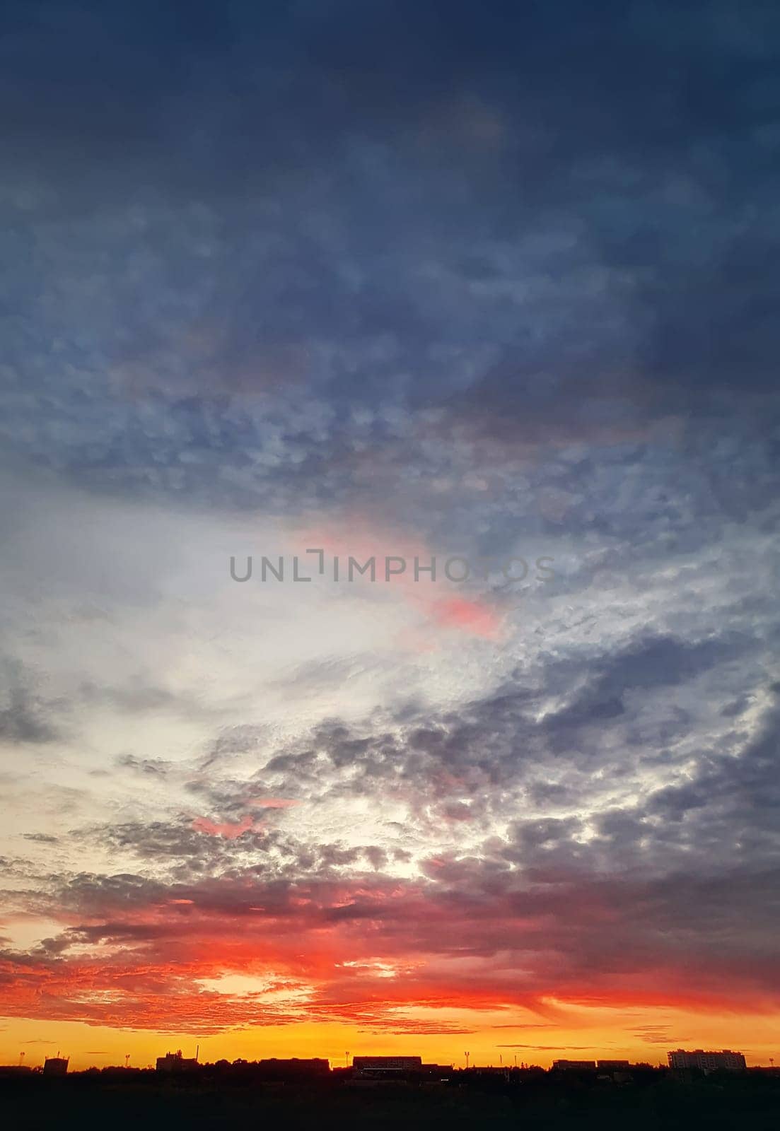 Dreamlike colorful sunset over the city horizon, vertical celestial  background