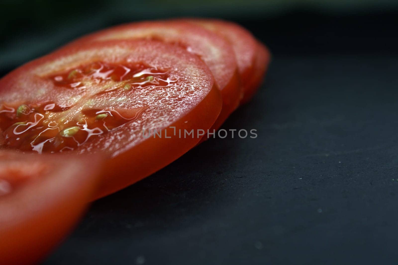 Close-up tomato slices on a black background. High quality photo