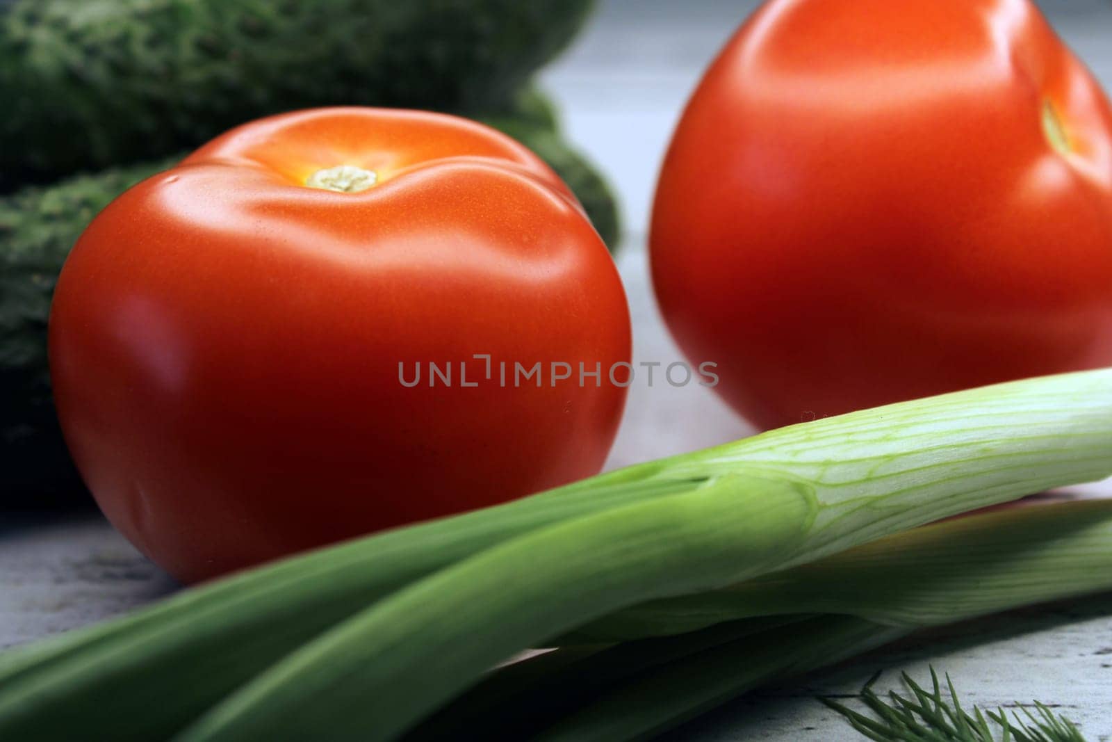 Cucumbers, tomatoes, green onions close-up. The concept of vegetarianism, healthy eating..