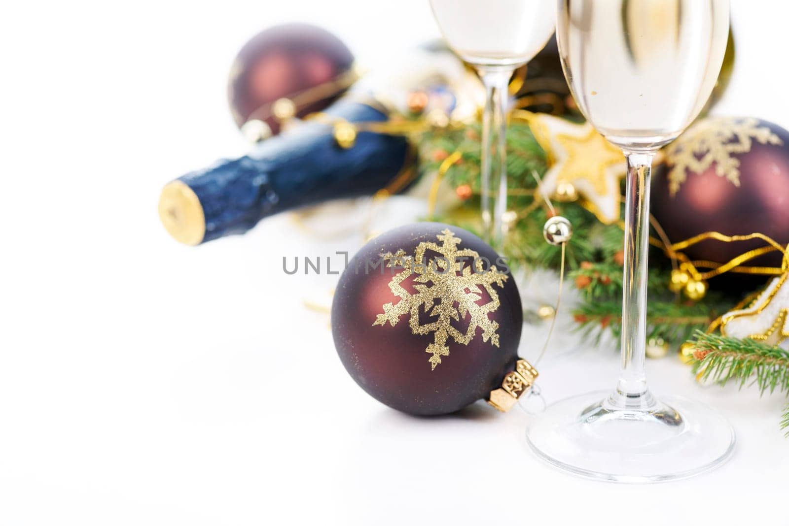 Christmas and new year celebration concept. Champagne glasses and christmas decoration with fir tree isolated over white background.