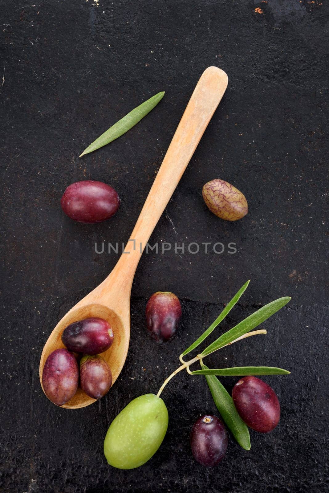 Fresh olive fruit on rustic black background. Top view image.