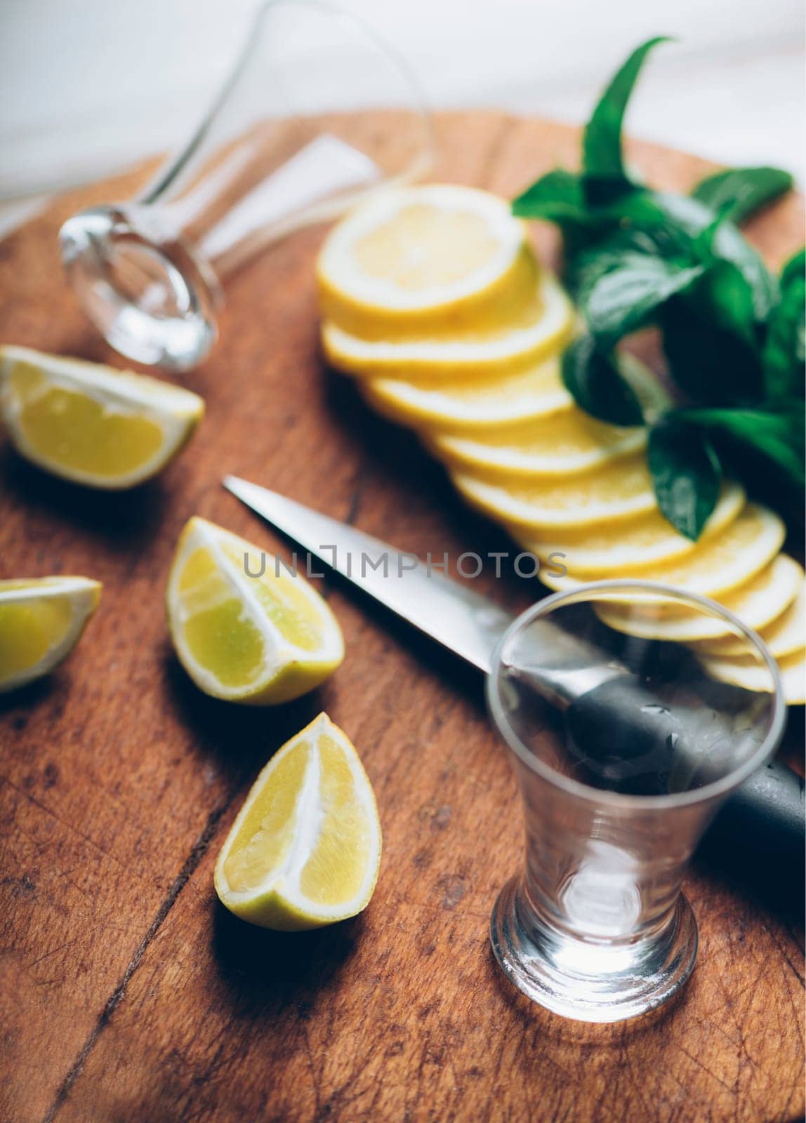 Ingredients for cocktail recipe making. Shot glasses set, citrus and mint on wooden board. Retro filter.