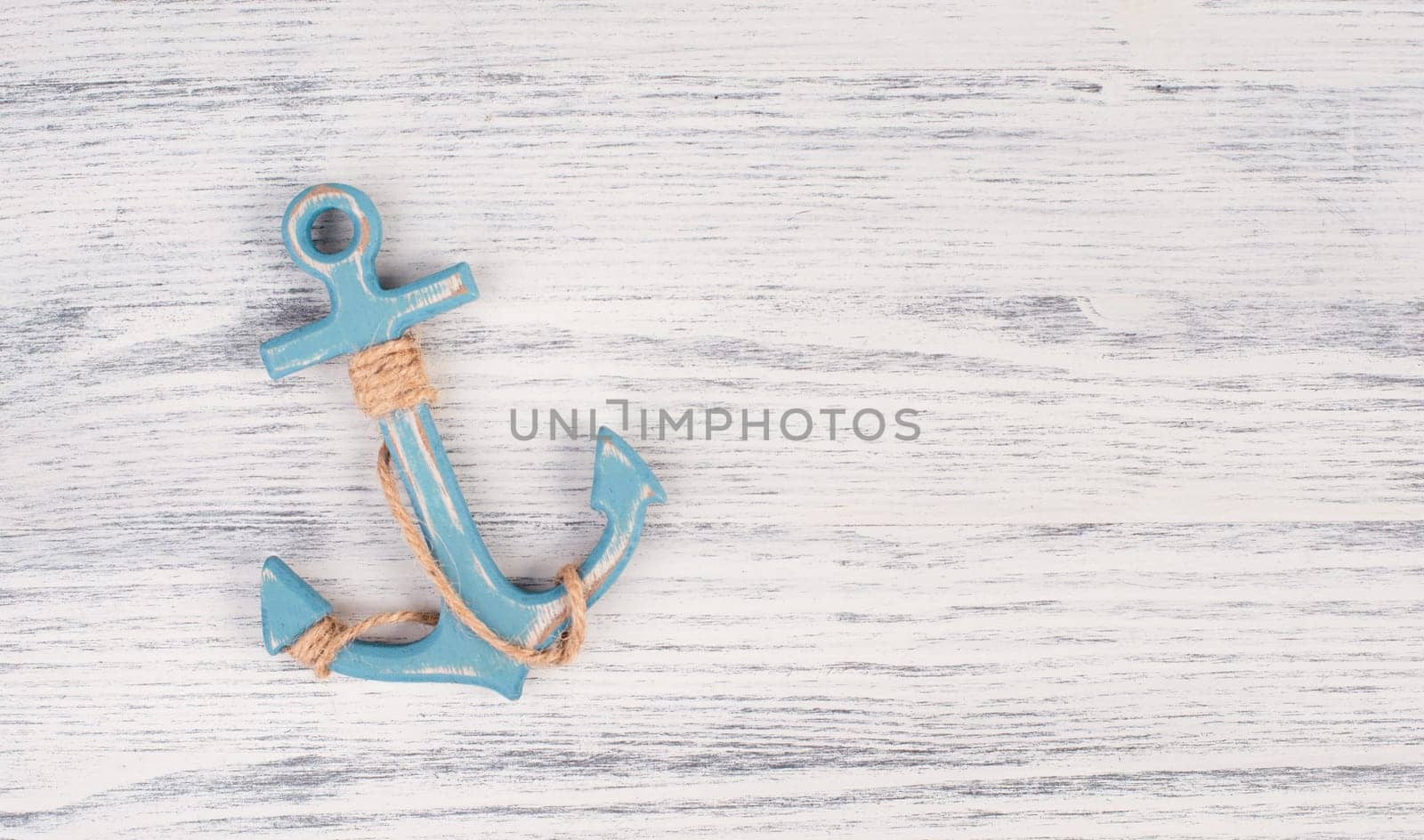 Blue anchor on a white textured background, maritime sea life, sailing trip, summer vacation, tourism concept, harbor