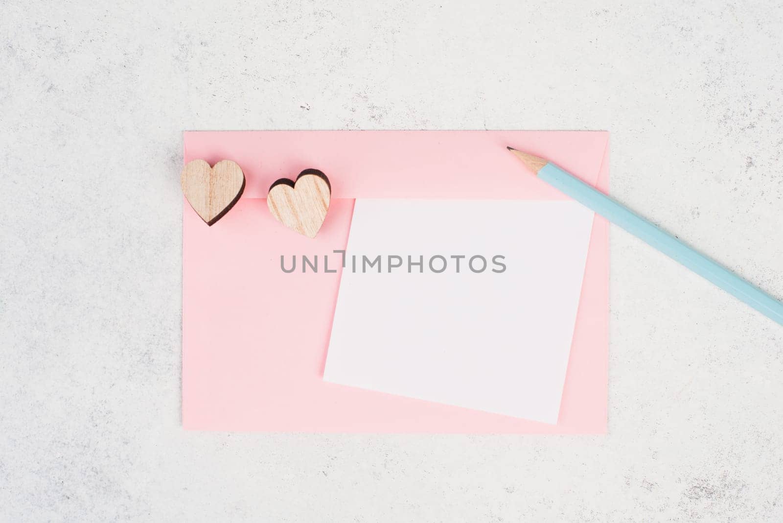 Pink envelope with hearts, empty copy space, blue pencil, valintines day greeting card, romantic mail, love letter