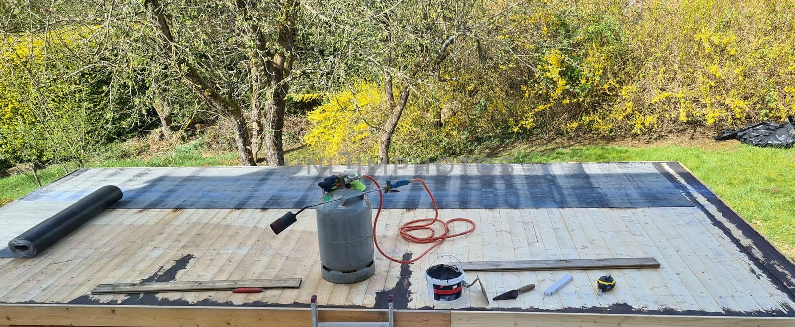 Roofing felt welding on bitumen roof roof repair with roofing felt and open flame propane tool on flat roof, leak with free space for text