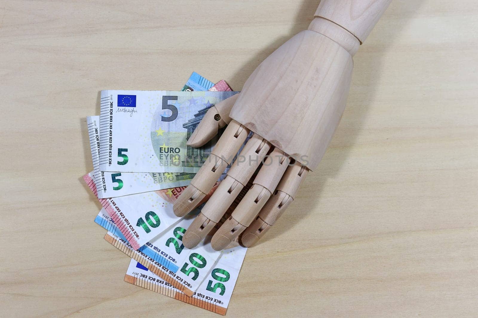 Life becomes more expensive. A wooden hand and banknotes