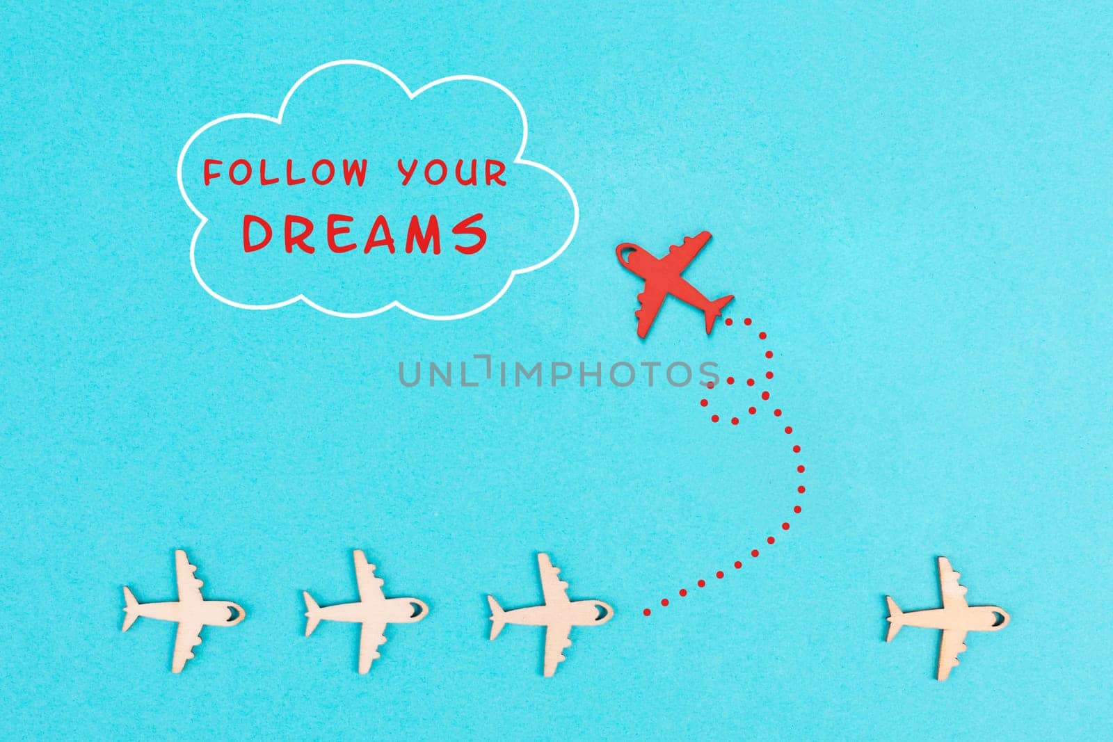 Red airplanes takes a different direction, flying to the cloud with the phrase follow your dreams, motivation and coaching concept, positive thinking, having a goal, mindset of freedom