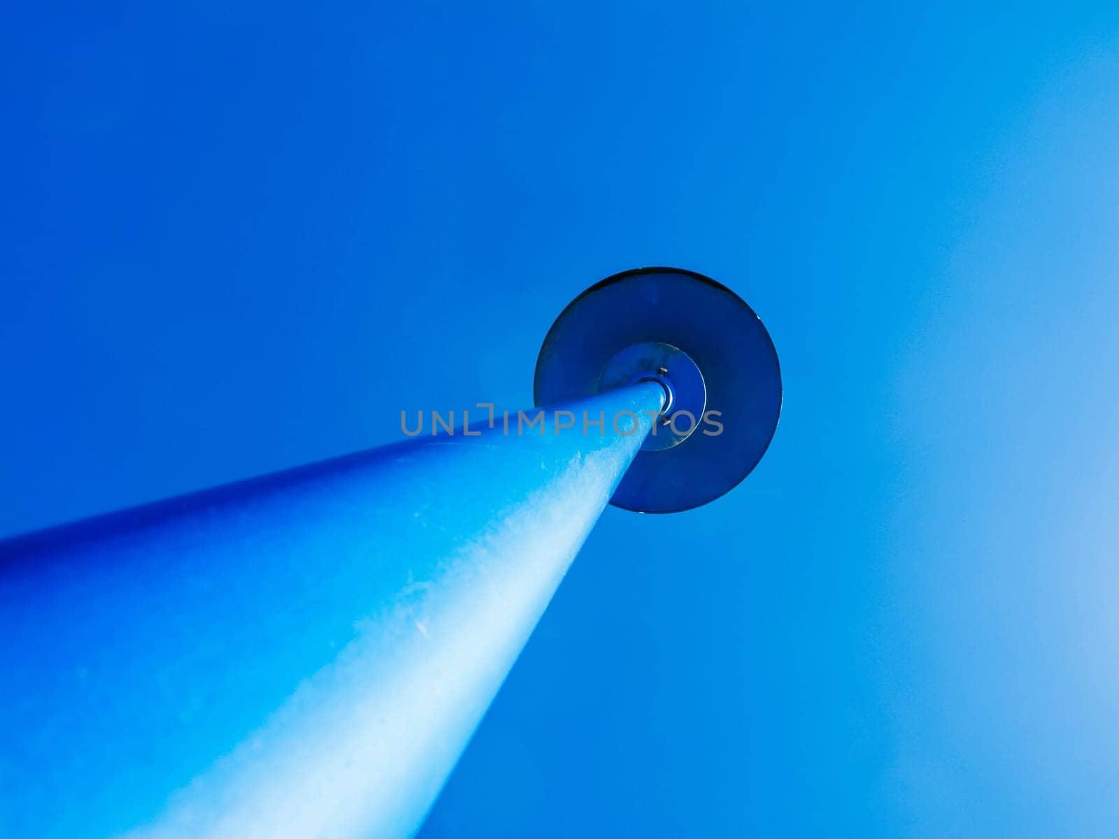 Perspective view of a blue lantern against a cloudless blue sky.