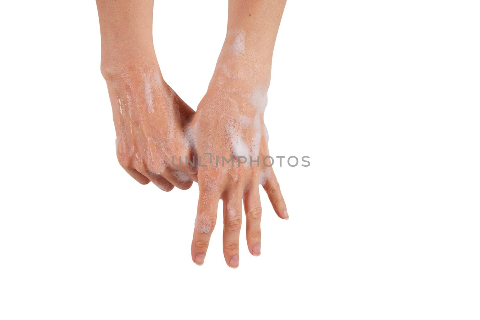 Crop female rubbing foamy thumb while washing hands with antibacterial soap against white background.