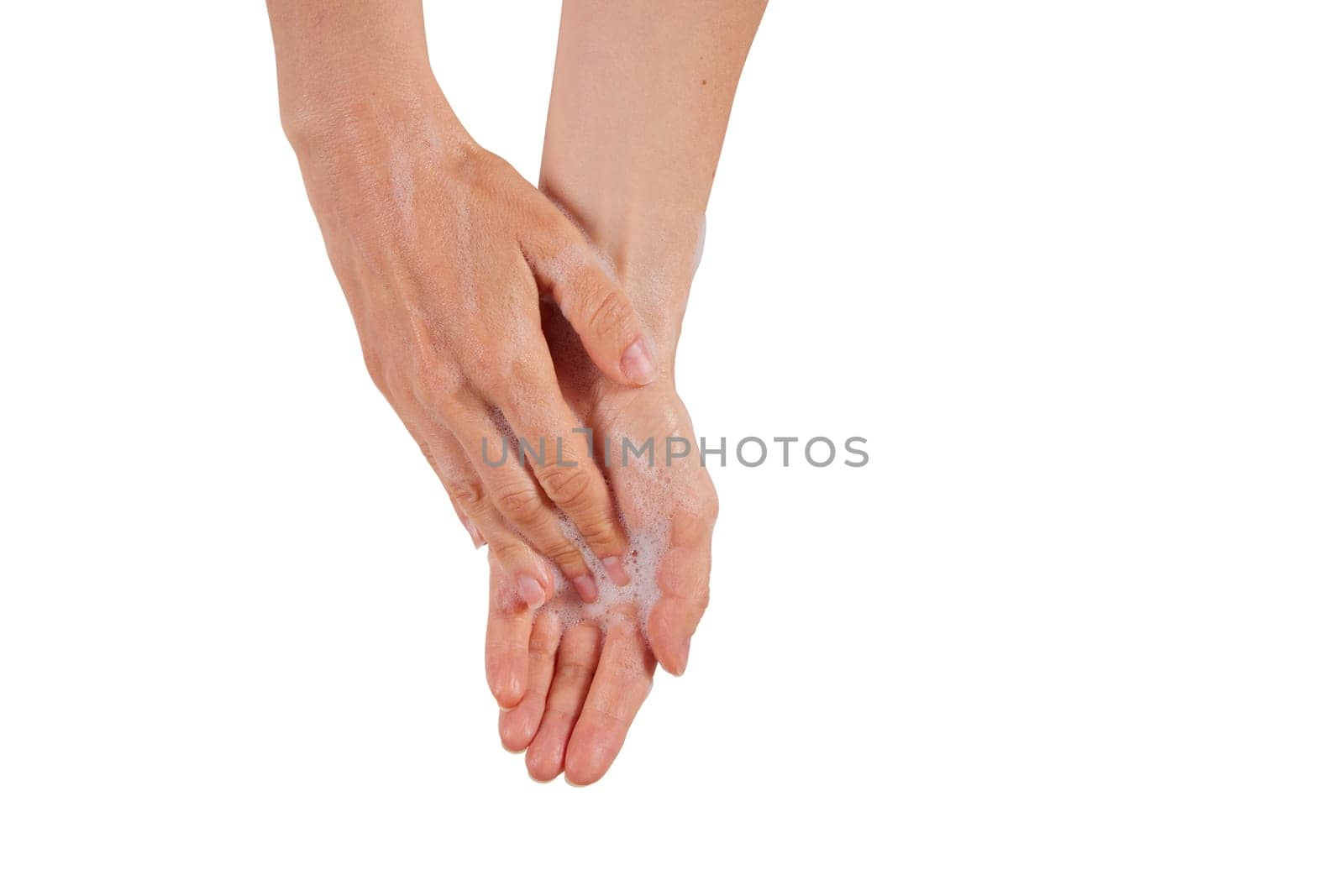 Unrecognizable female lathering open palm with soap while washing hands carefully against white background
