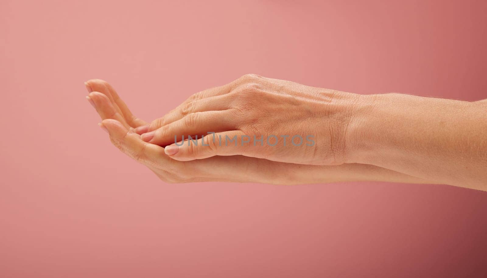 Woman hands on pink background for beauty concepts