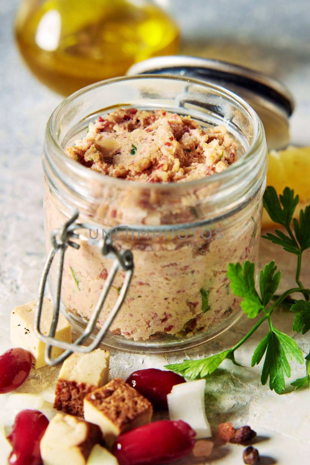 From above of delicious vegetarian leberwurst pate in glass jar placed on table near scattered kidney beans and cheese cubes in kitchen