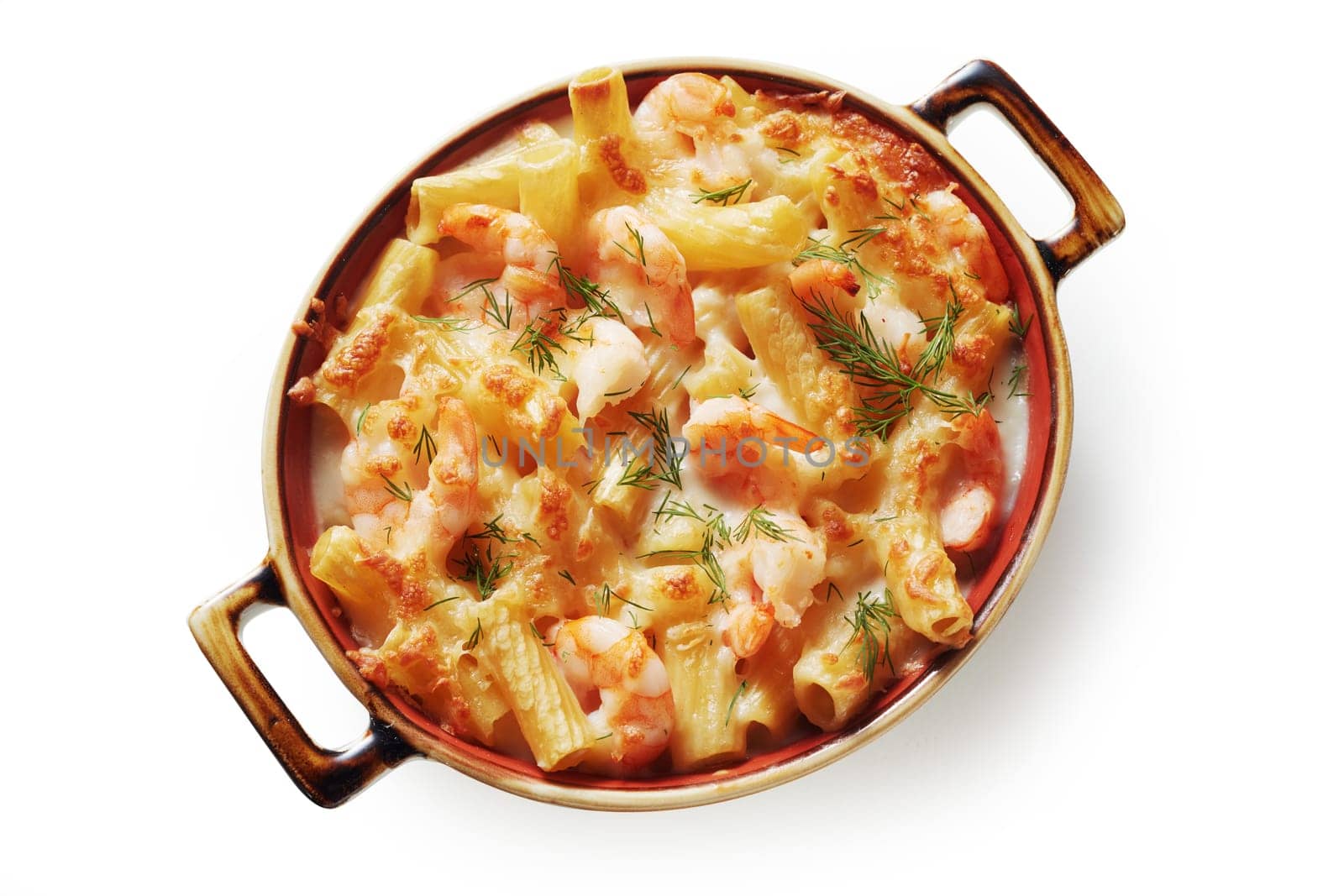 Top view of palatable rigatoni pasta with creamy sauce and shrimps prepared in saucepan and placed on white background