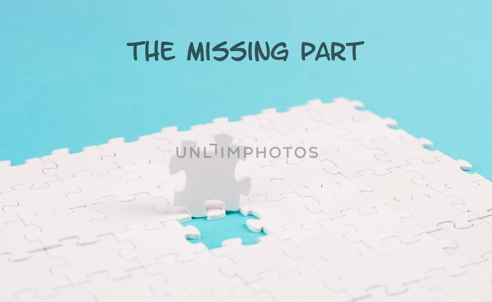 White jigsaw on a blue background, the missing part is standing on the paper, working together as a team, searching for solutions, the last piece
