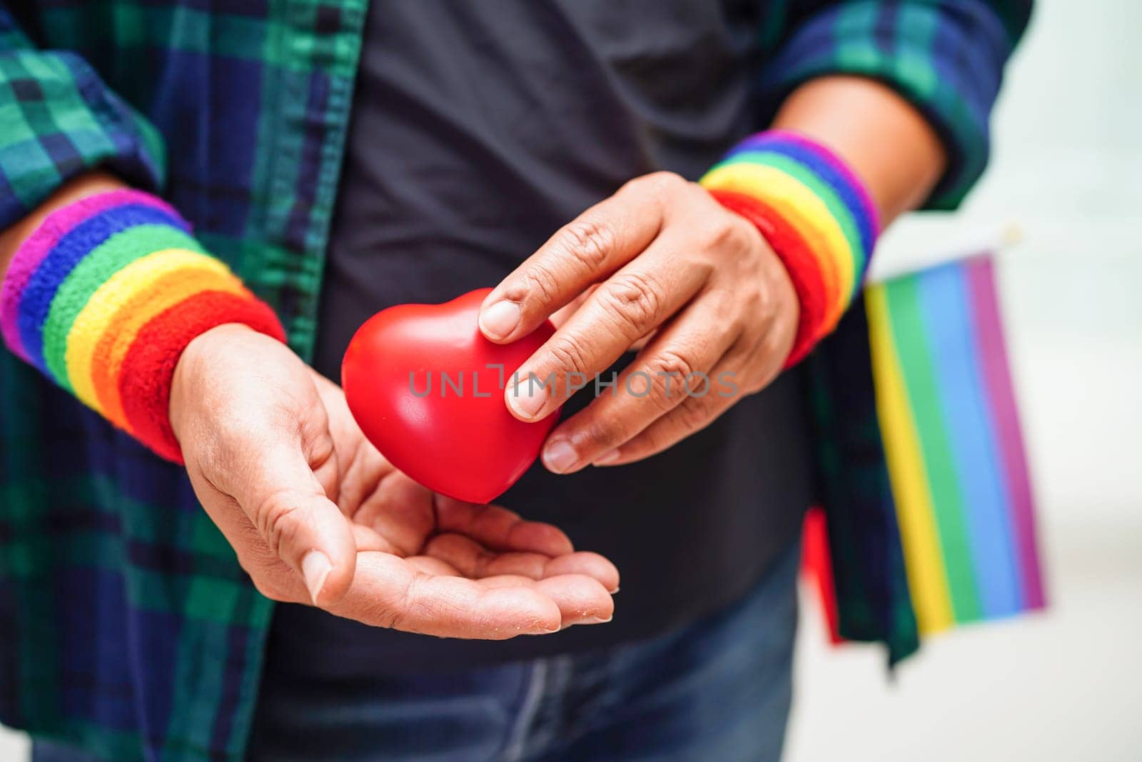 Asian woman holding red hert with rainbow flag, LGBT symbol rights and gender equality, LGBT Pride Month in June.