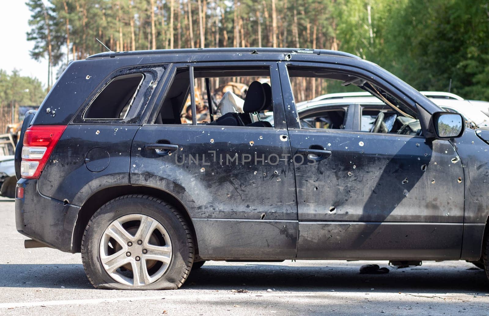 Shot car during the war in Ukraine. A car of civilians with shrapnel holes from explosions. Traces of shots on the body. The car was damaged after the shelling. Ukraine, Irpen - May 12, 2022