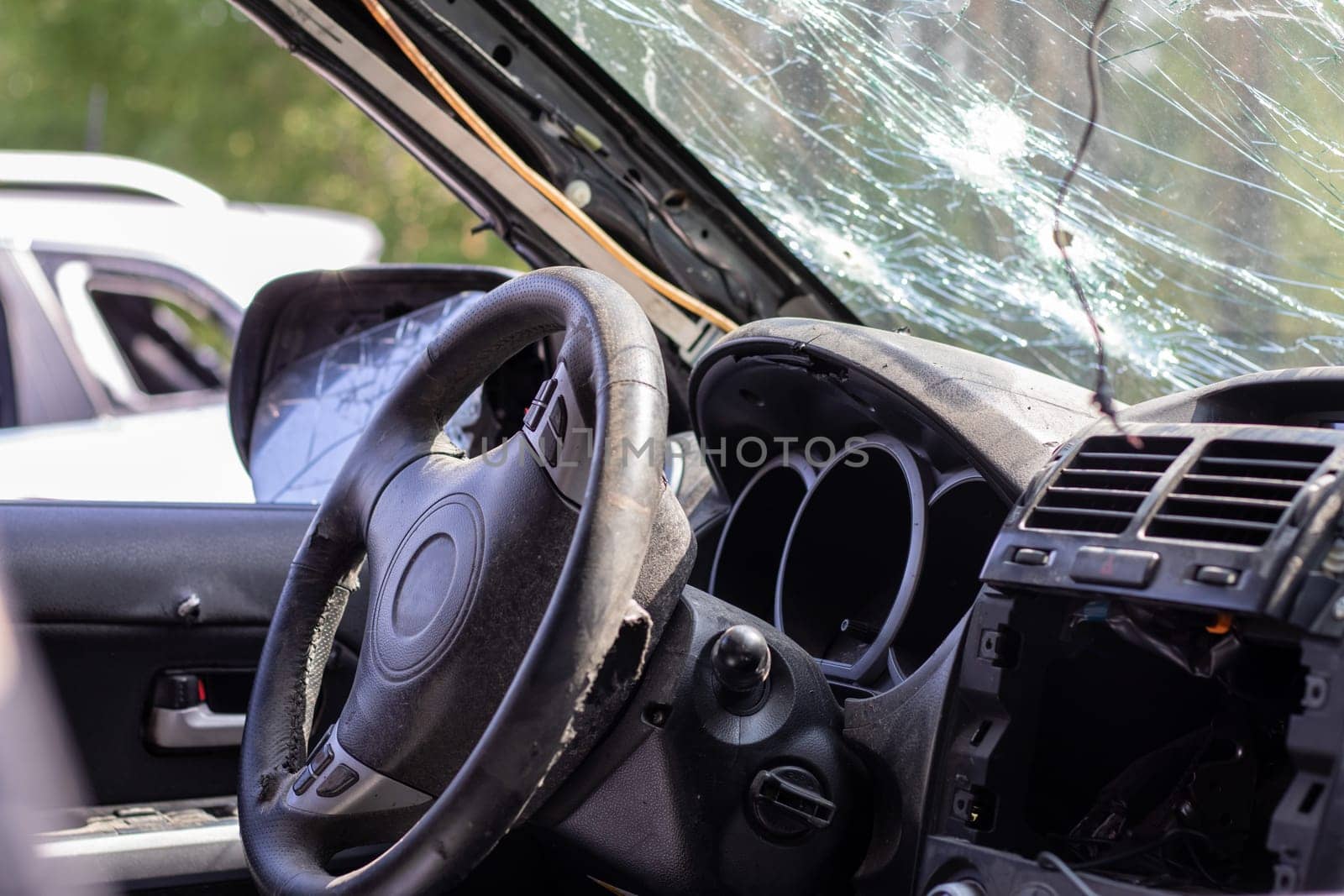 Shot car during the war in Ukraine. A car of civilians with shrapnel holes from explosions. Car accident. Car graveyard. Traces of shots on the body. The vehicle was damaged after the shelling