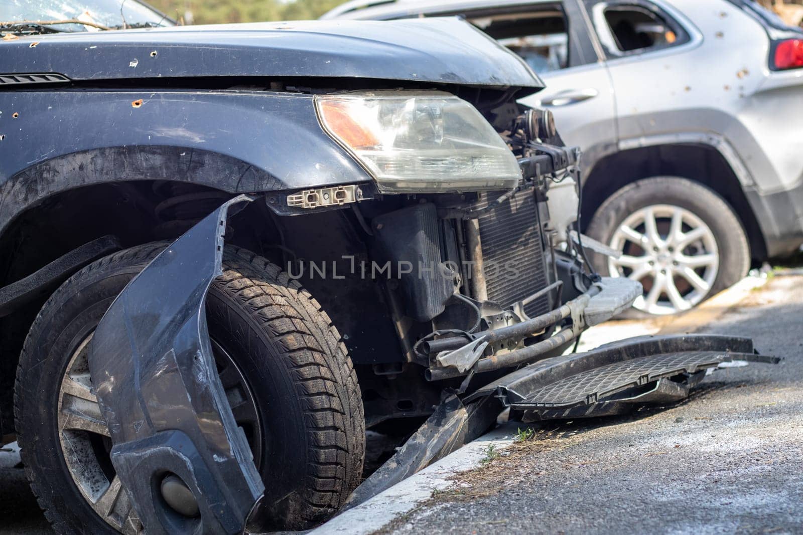 Shot car during the war in Ukraine. A car of civilians with shrapnel holes from explosions. Car accident. Car graveyard. Traces of shots on the body. The vehicle was damaged after the shelling