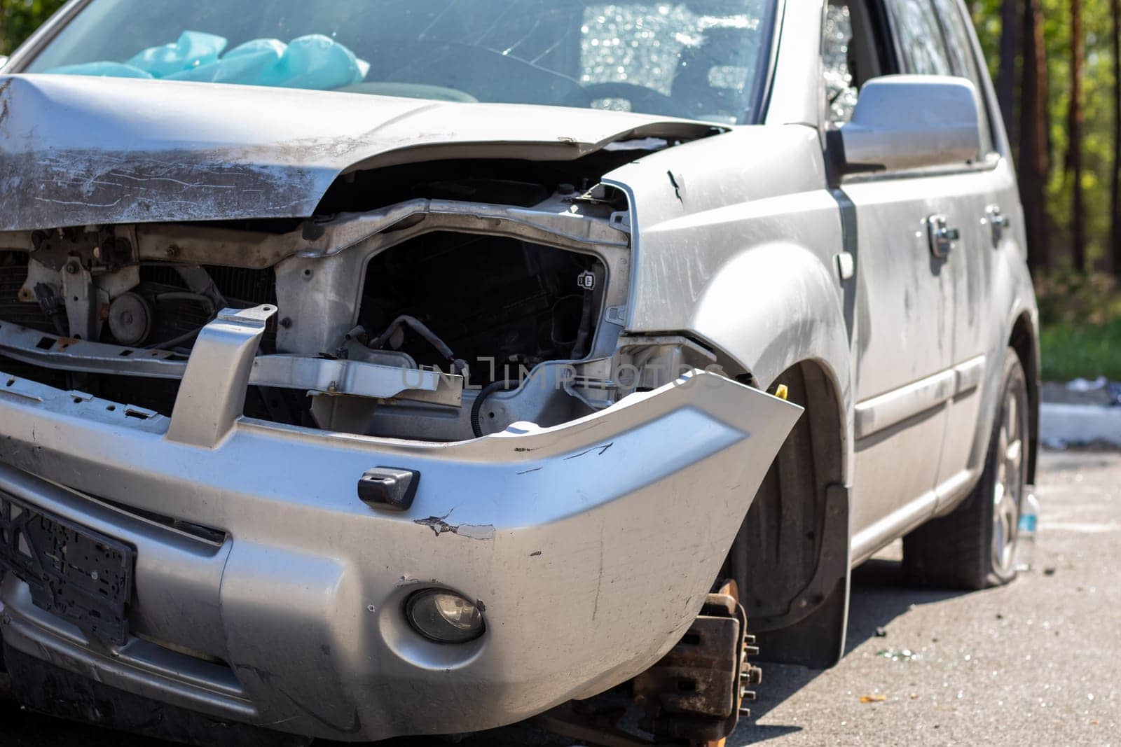 Broken headlights as a result of a collision. Broken gray car after an accident. Car accident concept. Damaged emergency headlight, hood and bumper. Damage to the car body after the accident