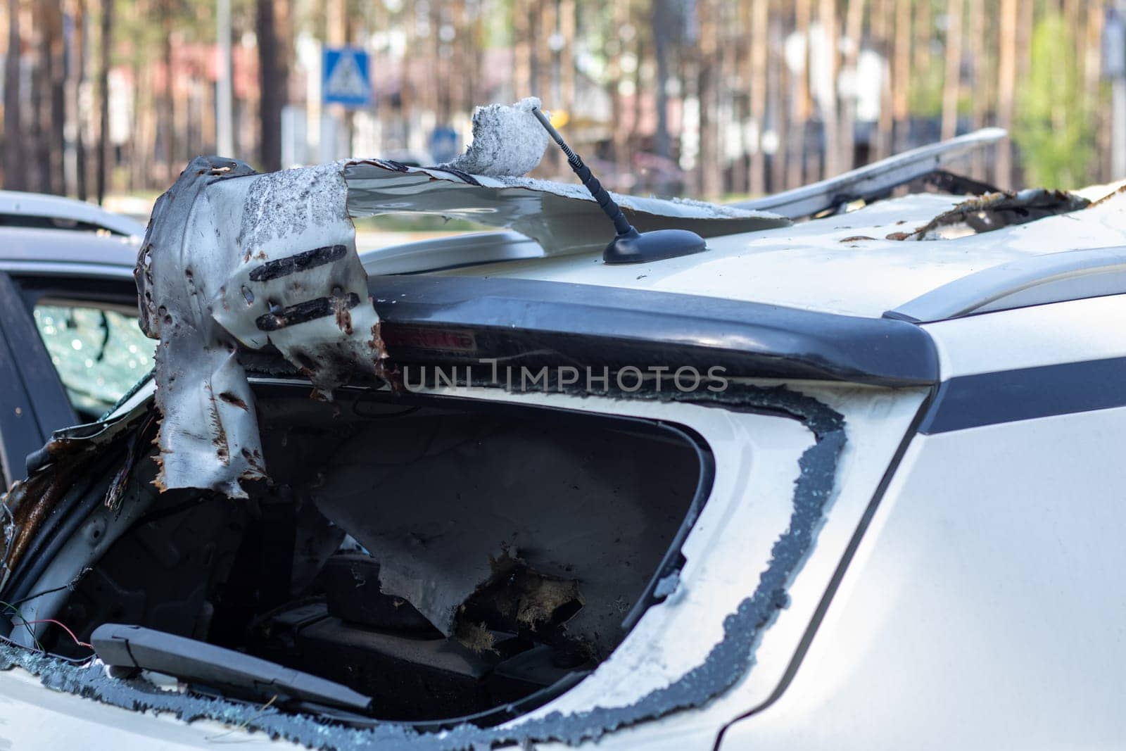 Shot car during the war in Ukraine. A car of civilians with shrapnel holes from explosions. Car accident. Car graveyard. Traces of shots on the body. The vehicle was damaged after the shelling