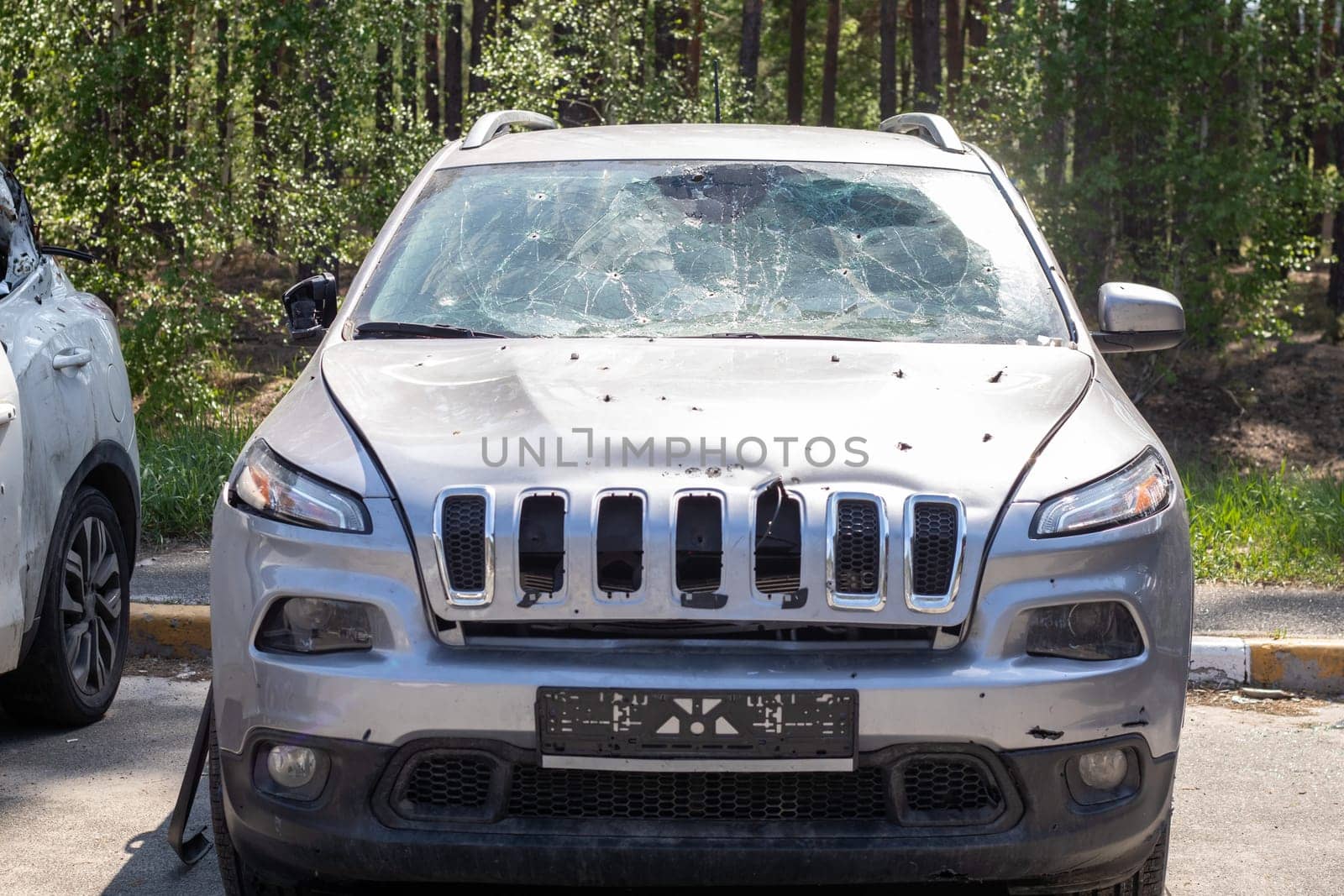 Shot car during the war in Ukraine. Car of civilians with shrapnel holes. Traces of shots on the body of the car. The car was damaged after the shelling. Ukraine, Irpen - May 12, 2022